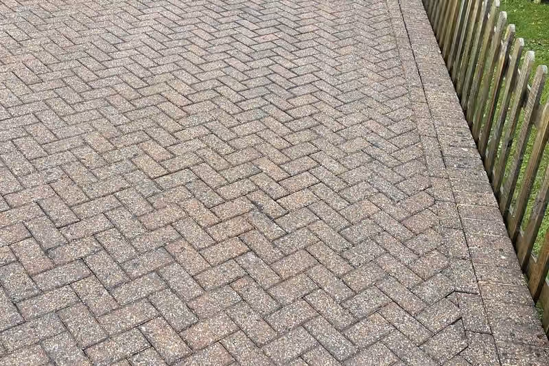 The same courtyard after jet washing and re-sanding, the herringbone pattern sharp again and the brick colour separating from the charcoal blocks